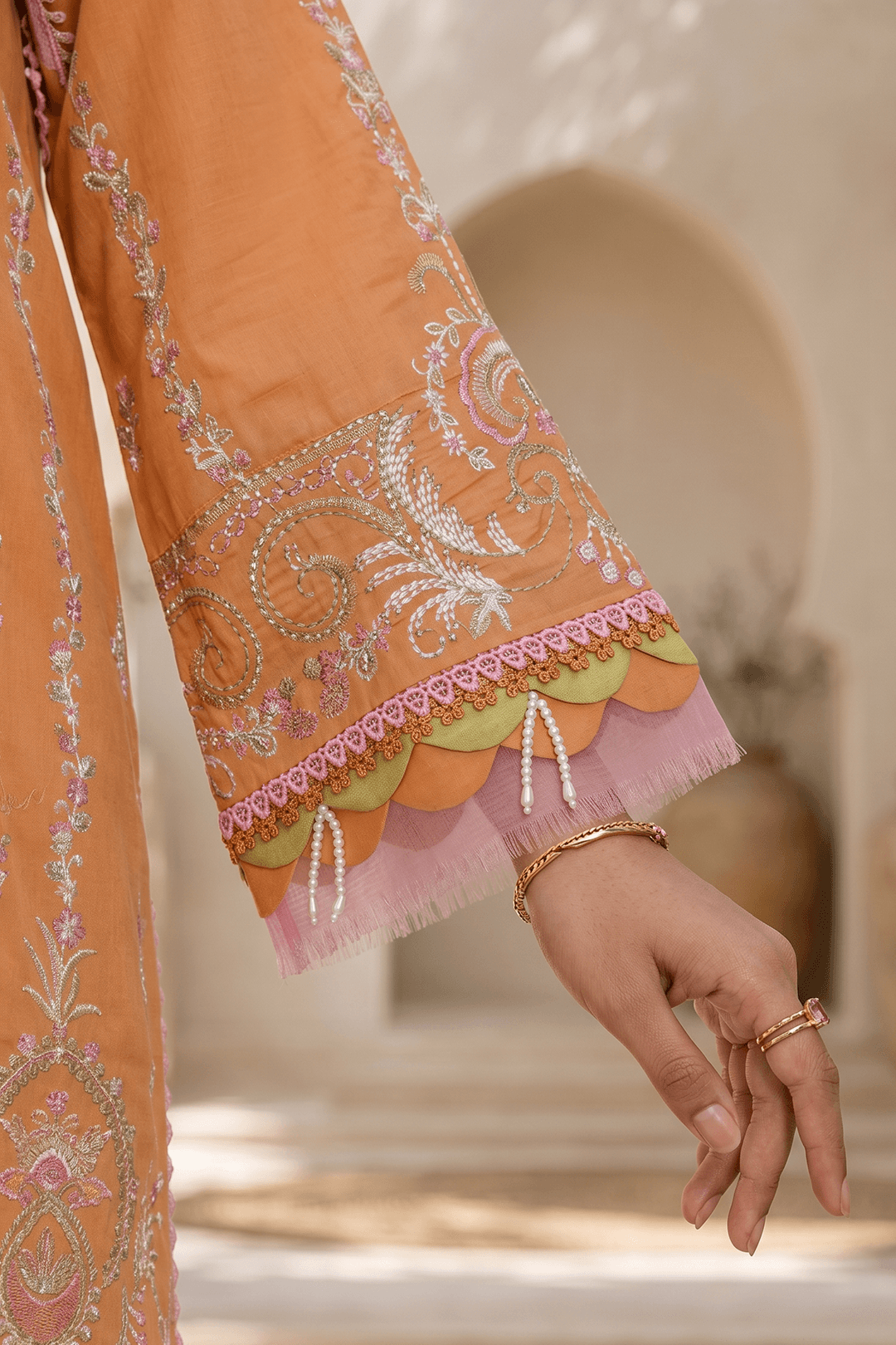 Close-up of an orange embroidered outfit with a blurred background