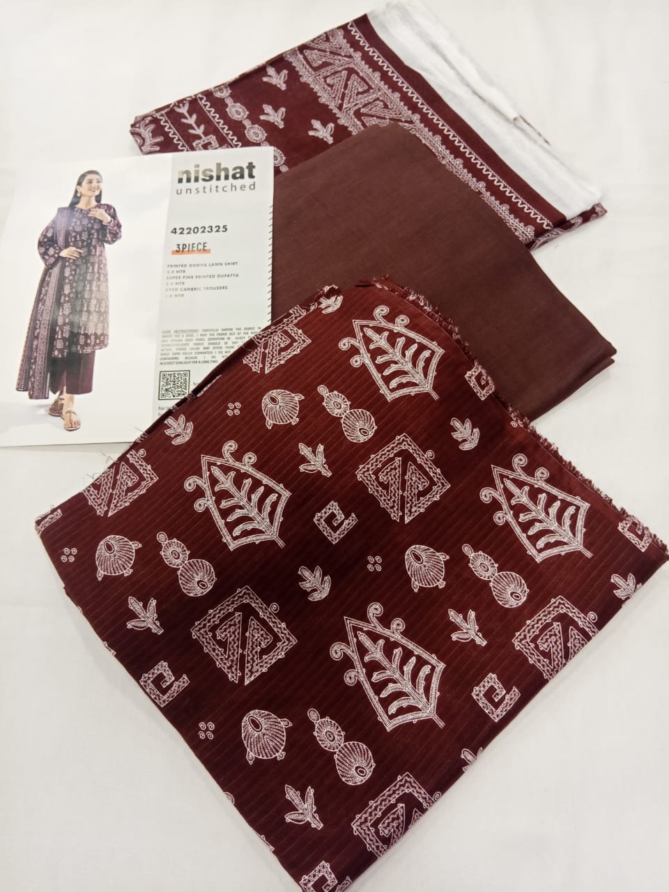 A model wearing the Nishat 3pc Unstitched Doriya Lawn Maroon suit