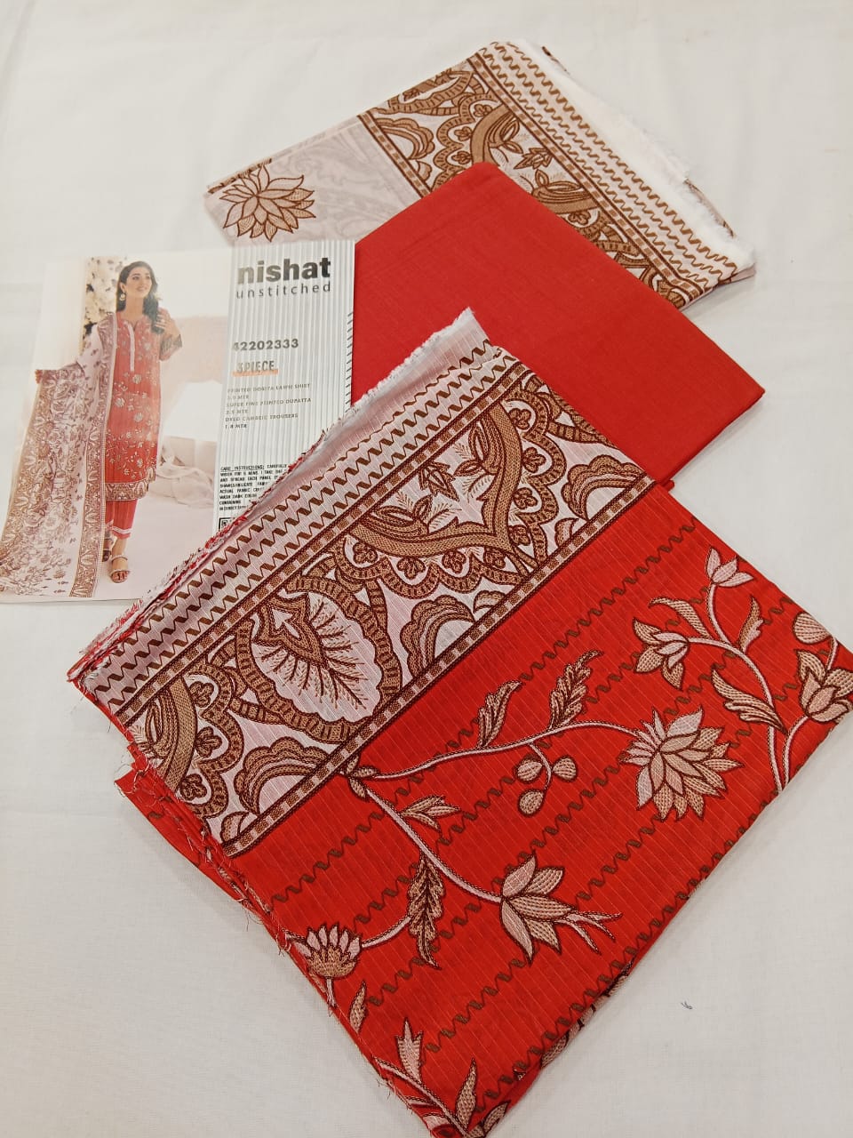 A model wearing the Nishat 3pc Unstitched Doriya Lawn Red suit