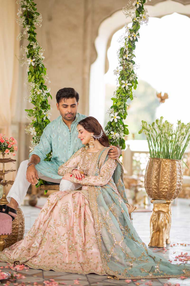 Hania Embroidered Net Gharara worn by a couple in a beautifully decorated outdoor setting with floral arrangements.
