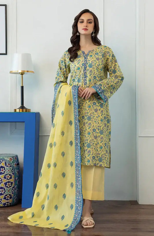 A woman models a yellow and blue floral printed salwar kameez suit with a matching dupatta in a styled indoor setting.