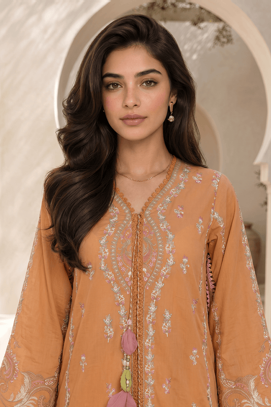 Woman wearing a mustard yellow embroidered traditional outfit with a decorative necklace.