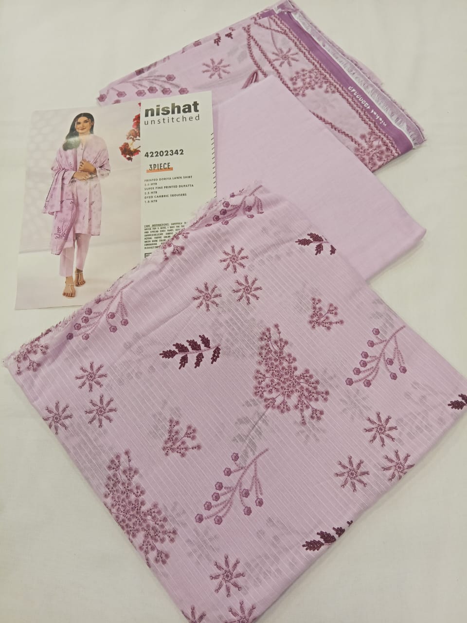 A model wearing the Nishat 3pc Unstitched Doriya Lawn Light Pink suit