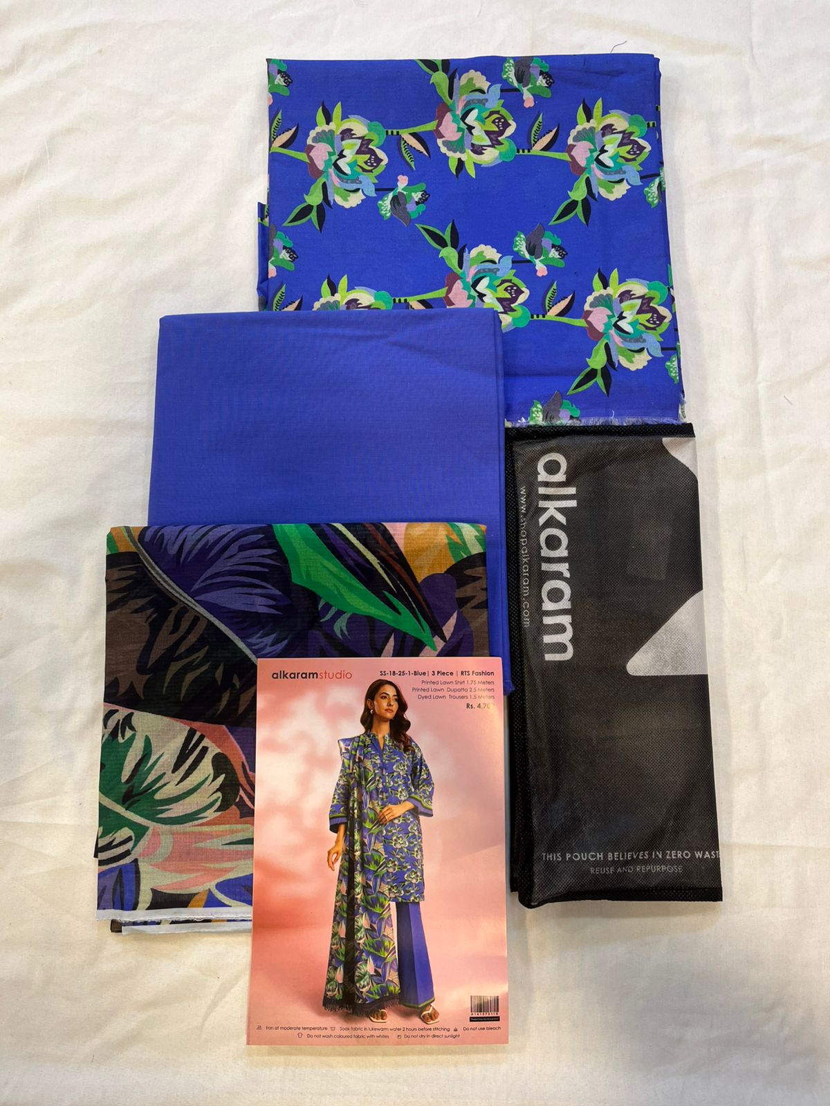 Blue - Alkaram 3pc Unstitched Lawn Suit includes printed lawn shirt, dupatta, and dyed trousers.