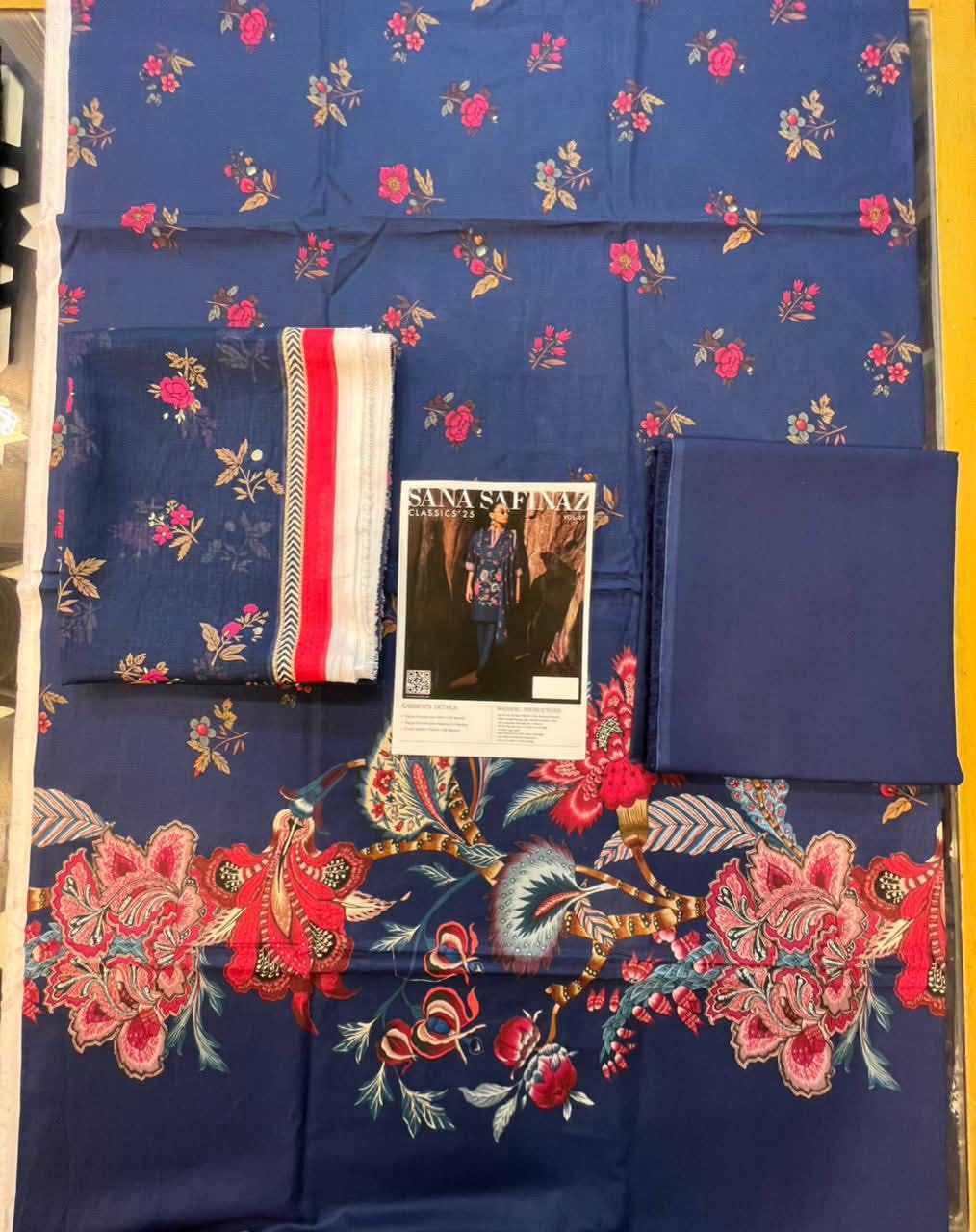 Blue fabric with floral patterns and embroidered designs on a yellow background