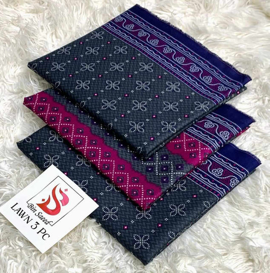 Set of three patterned fabric pieces on a white fluffy surface with a brand label.