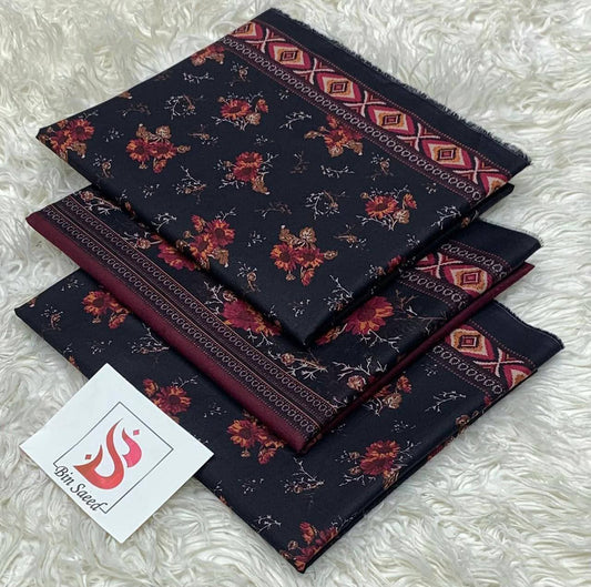 Set of patterned fabric swatches on a textured surface with a brand card.