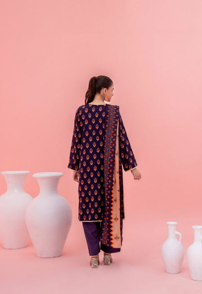 Woman wearing a dark blue embroidered outfit with a pink background