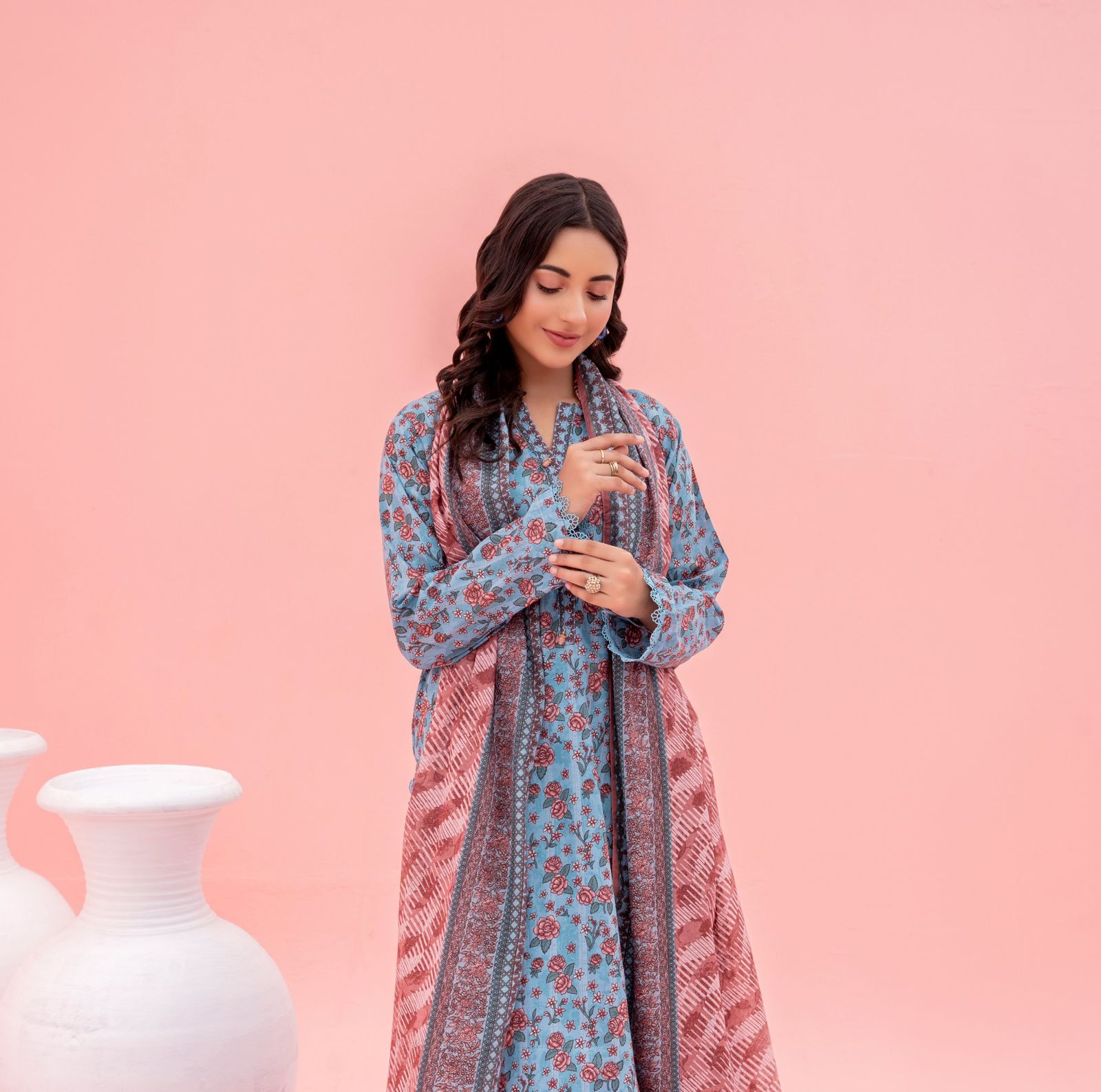 Woman wearing a floral dress against a pink background
