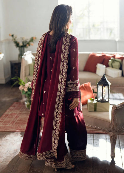 Model showcasing AZURE Chiffon Luxury Mehroon 3 PC outfit with intricate embroidery and elegant design in a cozy setting.