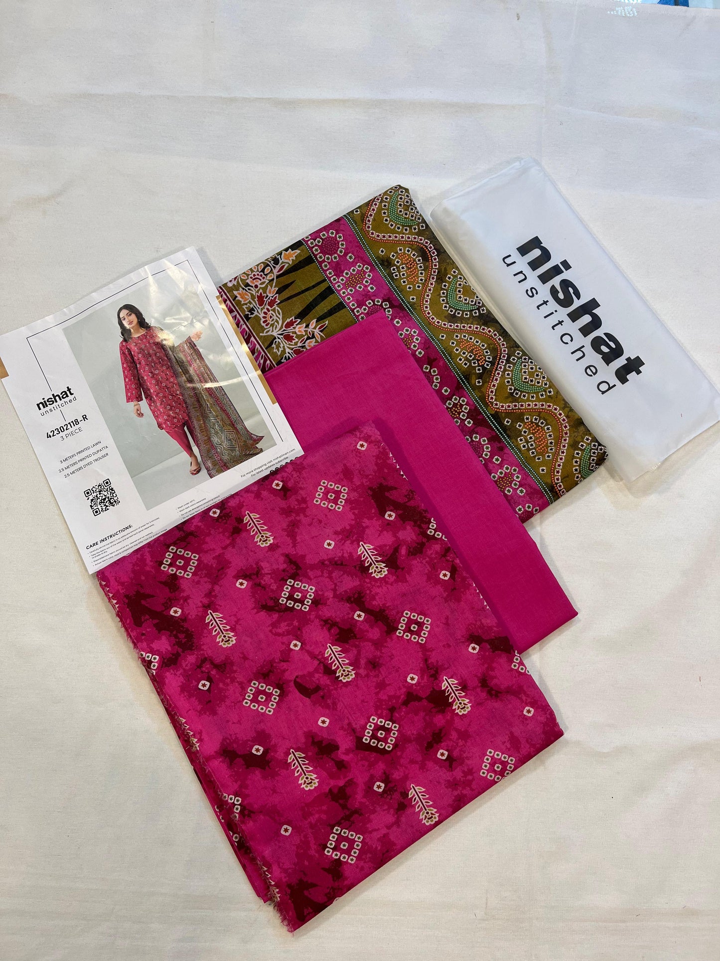 Nisha By Nishat 3pc Unstitched Lawn - Pink, includes fabric pieces and a printed shirt catalog.