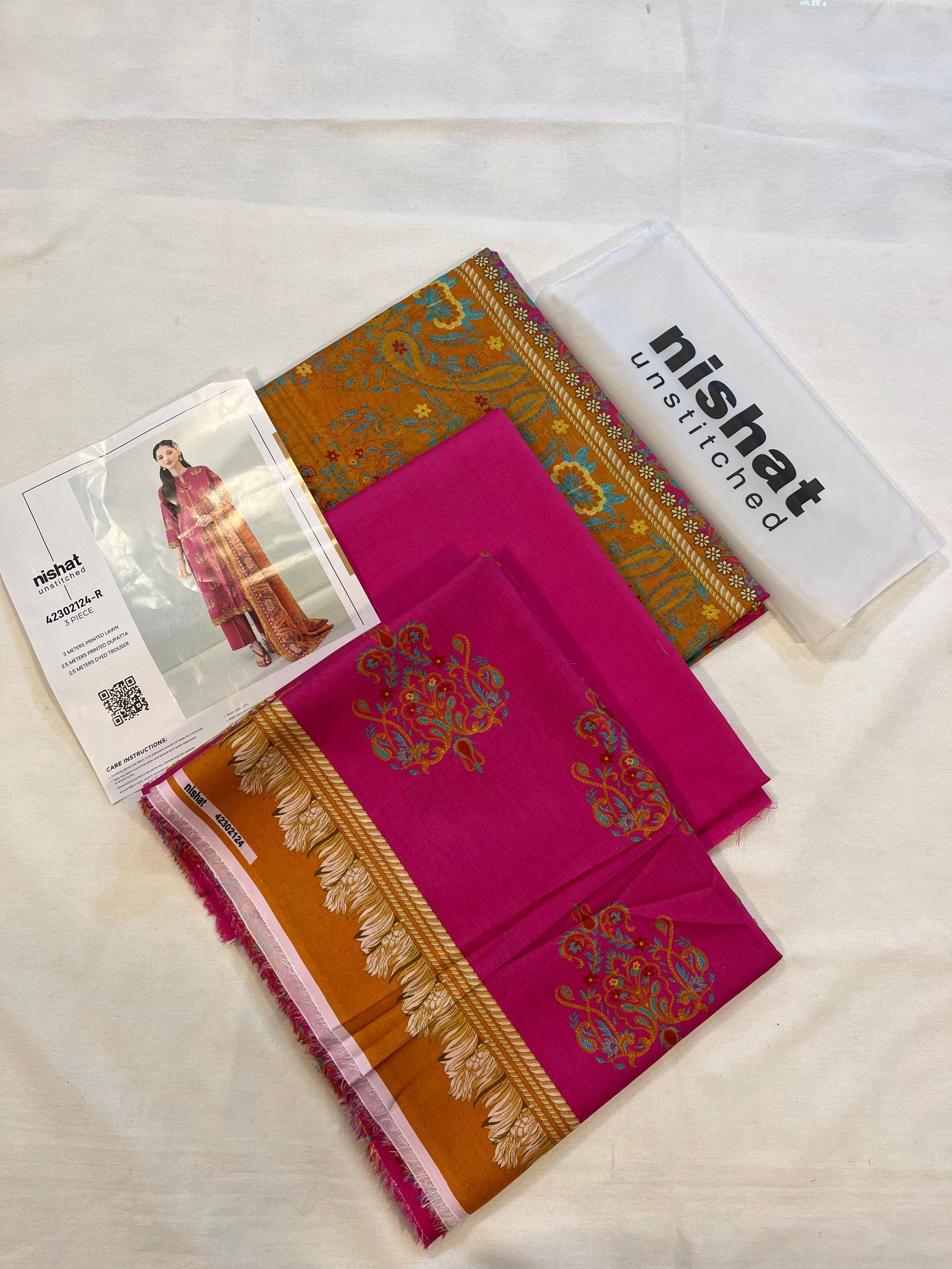 Nisha By Nishat 3pc Unstitched Lawn - Pink, includes fabric pieces and a printed shirt catalog.